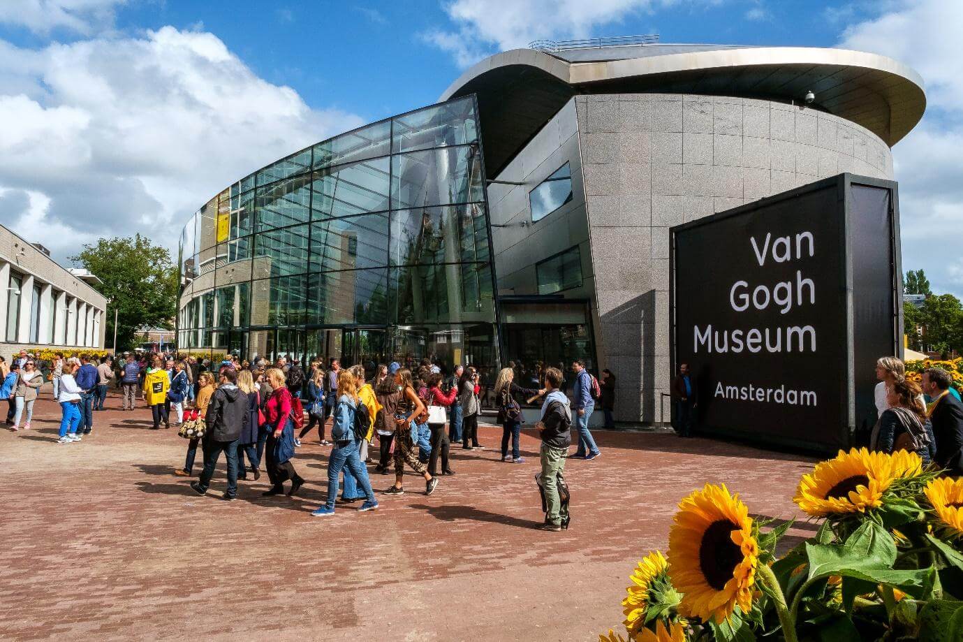 Front view of the Von Gogh museum. Visitors standing in front of the musuen in Amsterdam, Netherlands.